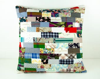 Könnte beinhalten: Ein Patchwork-Kissenbezug mit einer Vielzahl von bunten Stoffen, darunter Blumenmuster, Streifen und Karos. Der Kissenbezug besteht aus einer Mischung aus Baumwolle und Leinen.
