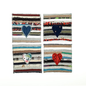 Peut inclure: Quatre dessous-de-verre faits à la main avec un motif en tissu rayé. Chaque dessous-de-verre présente une application en tissu en forme de cœur différente. Les cœurs sont bleus, rouges, floraux et bleus à pois blancs.