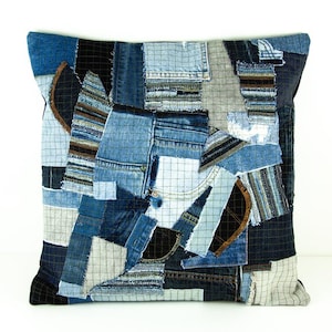 Peut inclure: Coussin carré décoratif avec un motif patchwork composé de différents tons de denim bleu. Le coussin présente un mélange de textures et de motifs, dont du tissu quadrillé et des poches en jean.