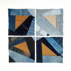 May include: Four square coasters with a patchwork design. Each coaster features a geometric pattern of denim in various shades of blue, with a tan leather triangle in the center. The coasters are arranged on a white background.