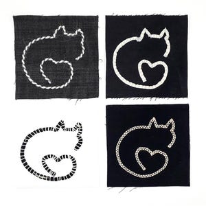Op de afbeelding: Vier vierkante stoffen patches met geborduurde kattenomtrekken. Drie patches zijn zwart met witte katten-silhouetten van draad, en één patch is wit met een zwart katten-silhouet. Elk katontwerp bevat een hartvorm in de staart.