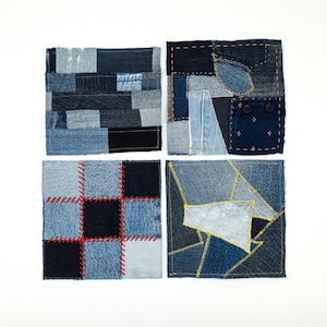 Op de afbeelding: Vier vierkante onderzetters gemaakt van patchwork denimstof. Elke onderzetter heeft verschillende blauwtinten, texturen en stikpatronen, waaronder rode en gele garenaccenten, zichtbare zakdetails en gevarieerde geometrische stoffen patronen.