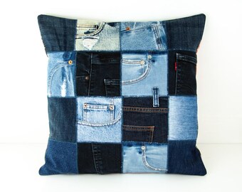 Könnte beinhalten: Quadratisches Kissen aus Jeans-Patchwork. Das Design zeigt verschiedene Blautöne von Jeansstoff, mit sichtbaren Taschen-Details. Das Kissen hat einen einfarbigen blauen Jeans-Rand und misst ca. 40 cm x 40 cm.