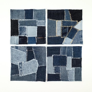 Puede incluir: Cuatro parches cuadrados de mezclilla dispuestos en una cuadrícula. Cada parche es un diseño de patchwork único, con varios tonos de mezclilla azul. Las piezas están cosidas con hilo blanco, creando una apariencia texturizada y artesanal.