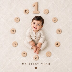 May include: A baby wearing a cream-colored ribbed long-sleeve romper with buttons, positioned in the center of a circular arrangement of wooden number discs from 1 to 11, with a large wooden number 1 at the top and the text MY FIRST YEAR below.