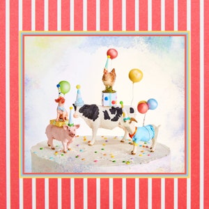 May include: A whimsical cake decorated with farm animal figurines wearing party hats and holding balloons. The cake features a pig, cow, goat, and chicken, with colorful confetti scattered around. The background has a red and white striped pattern.