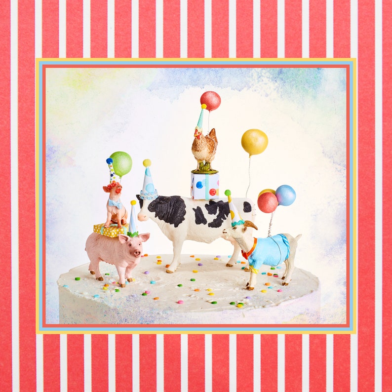 May include: A whimsical cake decorated with farm animal figurines wearing party hats and holding balloons. The cake features a pig, cow, goat, and chicken, with colorful confetti scattered around. The background has a red and white striped pattern.