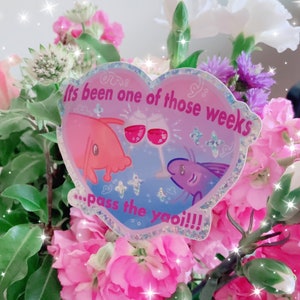 May include: A heart-shaped sticker with the text "It's been one of those weeks... pass the yaoi!!!" features two cartoon fish with wine glasses. The sticker is set against a backdrop of pink and white flowers.