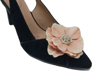 May include: Black suede heeled slingback shoe with a peach-colored fabric flower embellishment. The flower has a rhinestone center.
