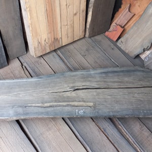 May include: A large piece of reclaimed wood with a natural grey finish. The wood is 18 inches wide and 75 inches long.