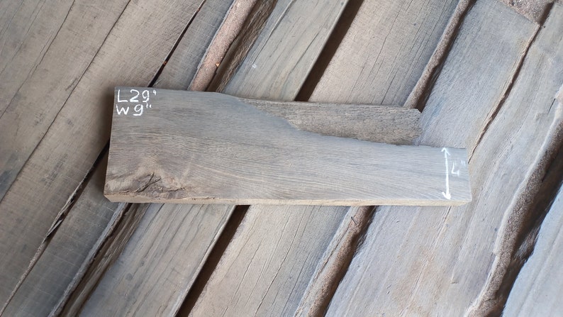 May include: A piece of reclaimed wood, measuring 29 inches long and 9 inches wide, with a gray finish. The wood has a natural grain pattern and is ready for woodworking projects.