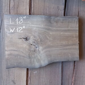 May include: A piece of wood with a natural grain pattern. It is 18 inches long and 12 inches wide. The wood has a knot in the centre.