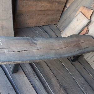 Puede incluir: Un banco de madera rústico con una parte superior de borde vivo y patas de metal negro. El banco mide 75 pulgadas de largo y 14 pulgadas de ancho.