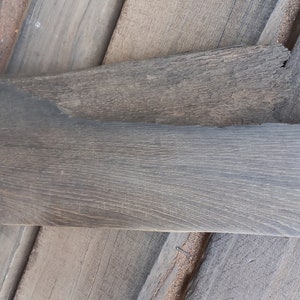 May include: A piece of reclaimed wood with a gray finish. The wood is 29 inches long and 1 1/4 inches wide.