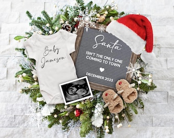 May include: A Christmas-themed baby announcement with a white onesie that says "Baby Jameson", a letter board that reads "Santa isn't the only one coming to town December 2023", a Santa hat, and a baby ultrasound image.