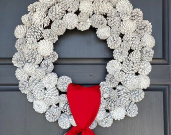 White Flocked Pinecone Wreath with wide Red Sash