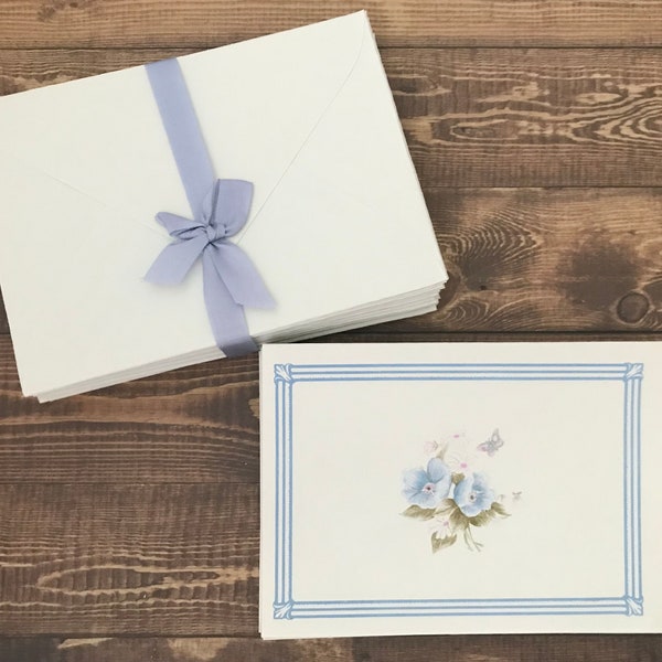 Vintage stationery set by Montag in pale blue with 17 folded notes with flowers and 20 envelopes. Made in USA.