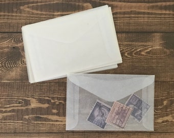 May include: A stack of white envelopes with a single envelope on top with three vintage postage stamps inside.