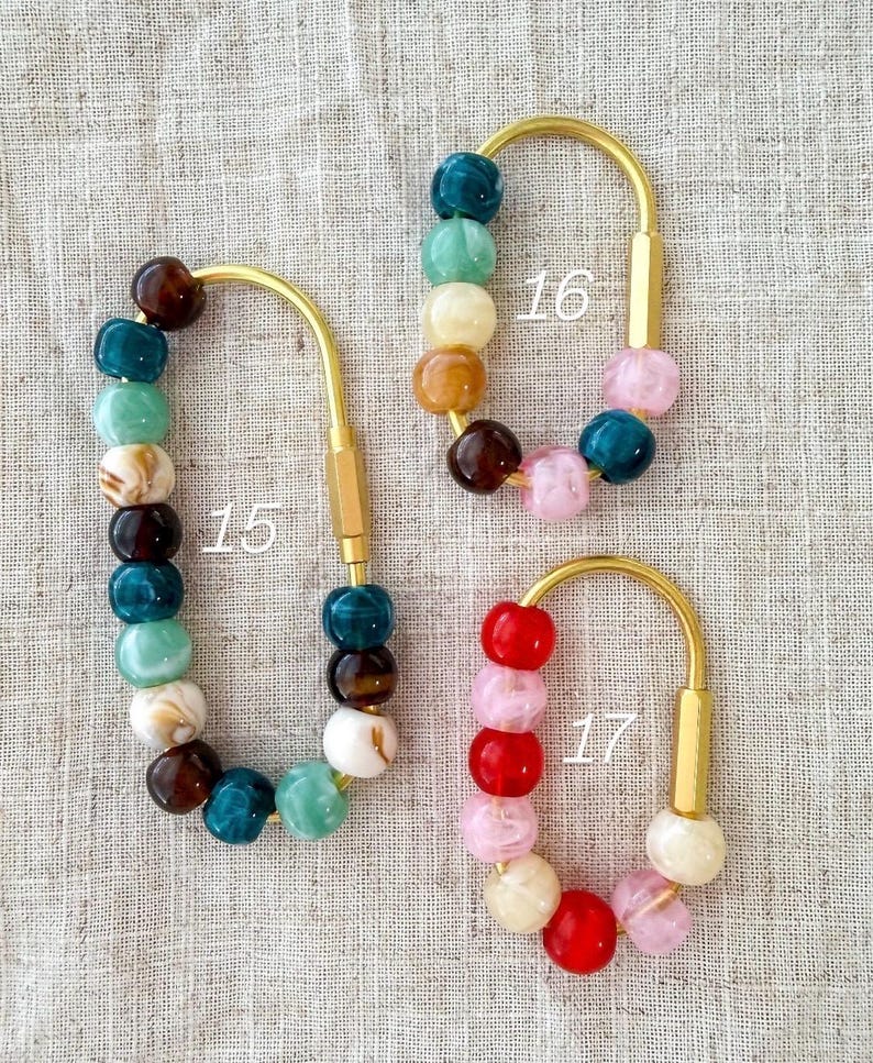 May include: Three keychains with gold-colored metal hardware and colorful beaded accents. The keychains are labeled with the numbers 15, 16, and 17. The beads are in shades of teal, brown, pink, red, and white.