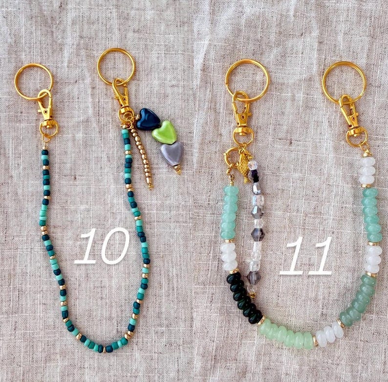 May include: Keychains with gold-colored hardware and beaded accents. One keychain features teal and gold beads, while another has a mix of green, white, black, and clear beads. The number "10" and "11" are printed on the image.