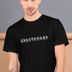 May include: Black t-shirt with a white graphic print of the word "GHOSTBANE" in a stylized font.