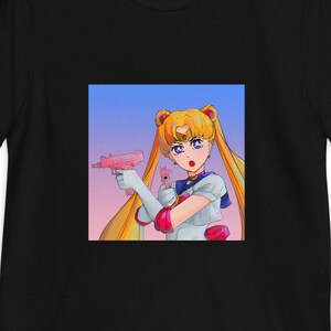 May include: Black t-shirt with a graphic of a cartoon anime character with blonde hair holding a pink gun. The background is a gradient of blue, pink, and purple.