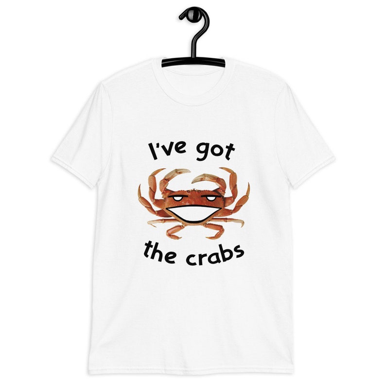 May include: White t-shirt with a black graphic of a crab with a smiling face and the text "I've got the crabs".