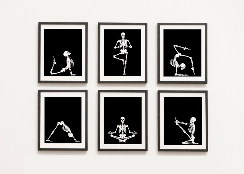 May include: Six framed art prints featuring white skeleton figures in various yoga poses against a black background. The prints are displayed on a white wall, each in a black frame, creating a cohesive and thematic set.