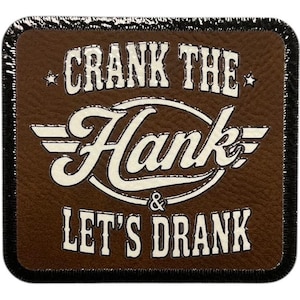 May include: A square brown coaster with the text "CRANK THE Hank & LET'S DRANK" in white. The coaster has a leather-like texture and a black border. The text is in a vintage, stylized font.