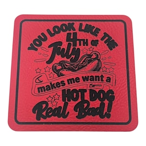 May include: A red square coaster with black text and a hot dog graphic. The text reads "YOU LOOK LIKE THE 4TH OF JULY makes me want a HOT DOG Real Bad!" Stars and decorative elements surround the text.