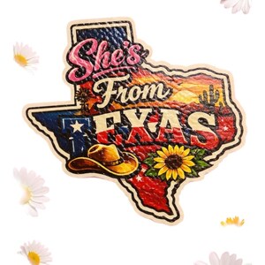 May include: A Texas-shaped graphic with the text "She's From Texas." The design features a cowboy hat, sunflower, and a sunset scene. The Texas flag is also incorporated into the design. Daisies are scattered around the graphic.