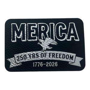 May include: Black rectangular patch with silver text and accents. The word "MERICA" is at the top, with an eagle below. A banner reads "250 YRS OF FREEDOM 1776-2026".