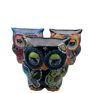 Puede incluir: Tres macetas de cerámica con forma de búho con diseños florales y geométricos coloridos. Los búhos tienen detalles en negro, azul, verde, naranja, amarillo y blanco.