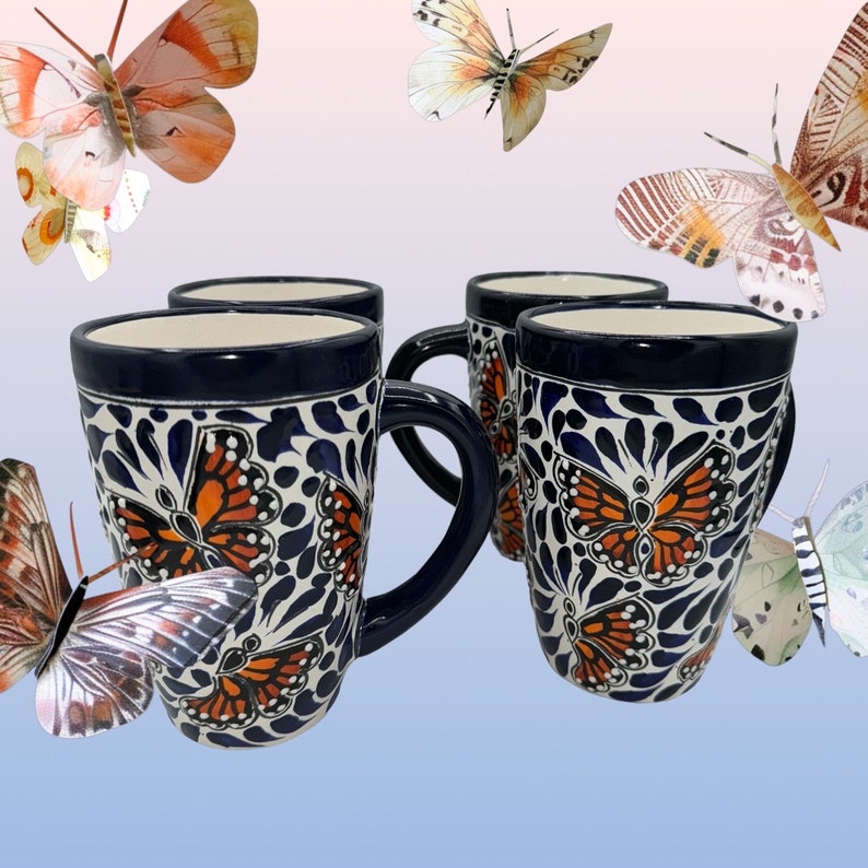 May include: Four blue and white ceramic mugs with orange butterfly designs. The mugs have a white background with blue and white floral patterns and orange butterflies.