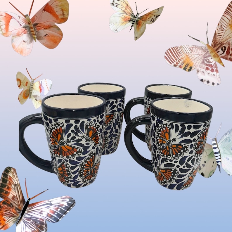 May include: Set of four blue and white ceramic mugs with orange butterfly designs. The mugs have a handle and are perfect for coffee or tea.