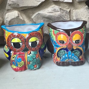 Puede incluir: Cuatro macetas de cerámica en forma de búho con diseños intrincados. Cada búho tiene un esquema de color diferente y presenta un patrón único de flores y formas geométricas.