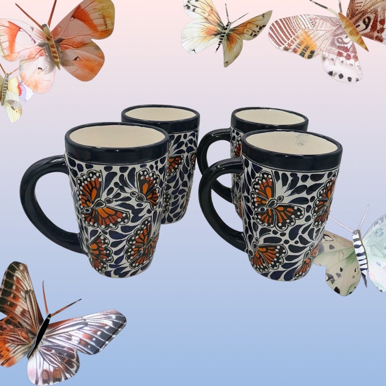 May include: Set of four ceramic mugs with a blue and white background and orange butterfly designs. The mugs have a handle and are perfect for coffee or tea.