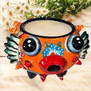 Maceta con forma de pez globo, muy linda y con mucha personalidad, pintada a mano en naranja con hermosos colores vibrantes, 8" x 12".