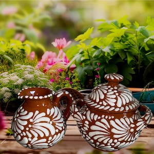 May include: A white ceramic mug with a black handle and the text "But First, Coffee" in a handwritten style. The mug is on a white surface. The mug is likely 11 ounces.