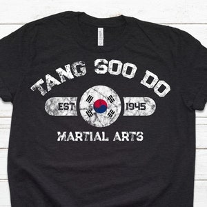May include: Black t-shirt with a white distressed graphic that says "Tang Soo Do" with the South Korean flag and "Est 1945" and "Martial Arts" underneath.