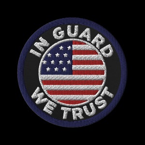 Könnte beinhalten: Gestickter Aufnäher mit einem kreisförmigen Design, das die amerikanische Flagge zeigt. Die Flagge hat rote und weiße Streifen und ein blaues Feld mit weißen Sternen. Die Worte "IN GUARD WE TRUST" sind in Weiß um die Flagge gestickt.
