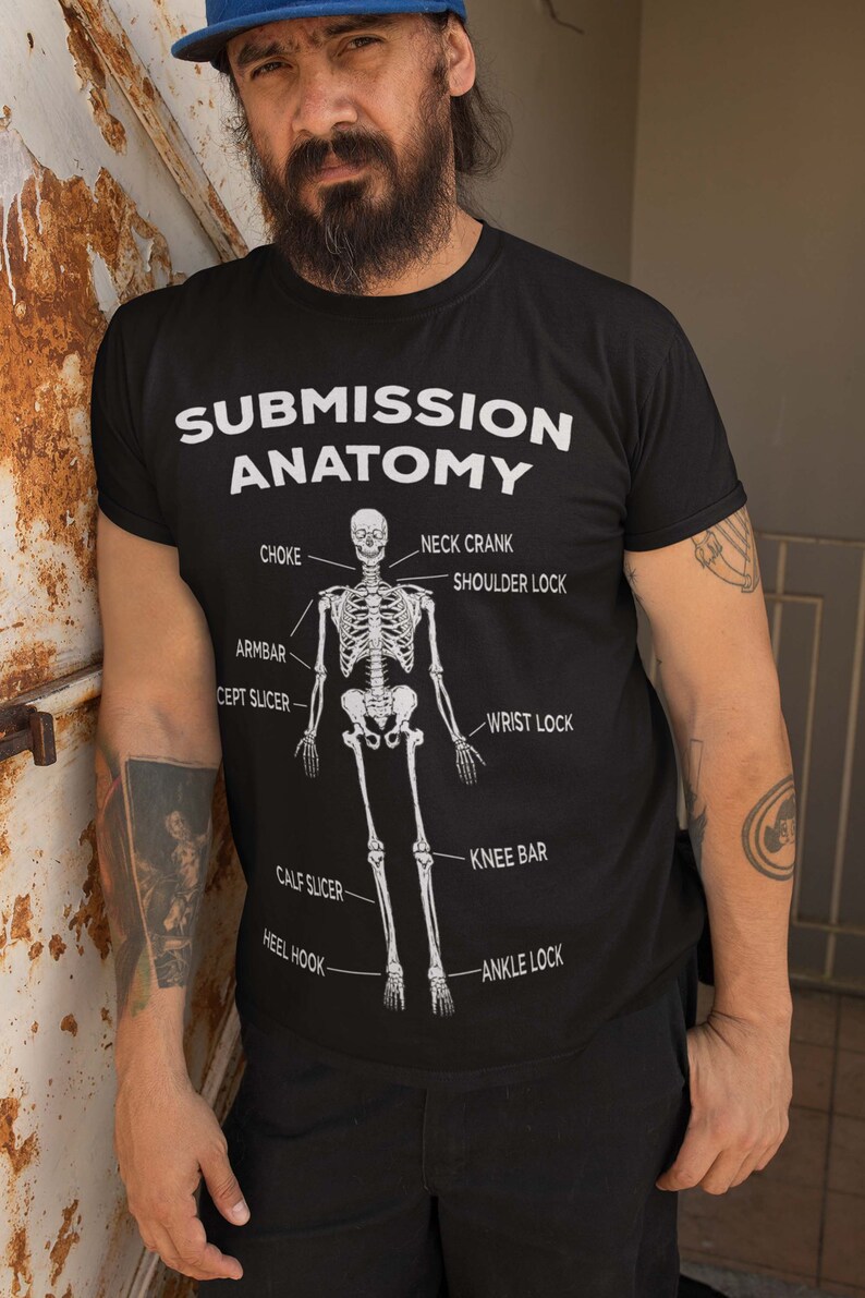 May include: A black t-shirt featuring a white skeleton graphic and the text "Submission Anatomy" with various submission holds labelled on the skeleton.