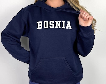 Könnte beinhalten: Ein marineblauer Hoodie mit einem weißen Aufdruck, der "BOSNIA" in einer College-Schriftart zeigt.