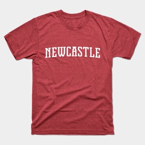 K&ouml;nnte beinhalten: Rotes T-Shirt mit wei&szlig;em Text, der "NEWCASTLE" lautet.