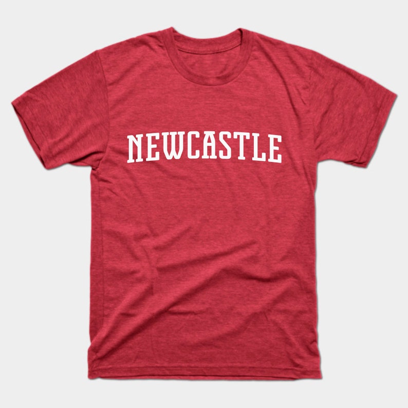 K&ouml;nnte beinhalten: Rotes T-Shirt mit wei&szlig;em Text, der "NEWCASTLE" lautet.