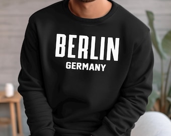May include: Black sweatshirt with white text that reads "BERLIN GERMANY".