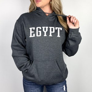May include: A dark gray hooded sweatshirt with the word "EGYPT" printed in white on the front.