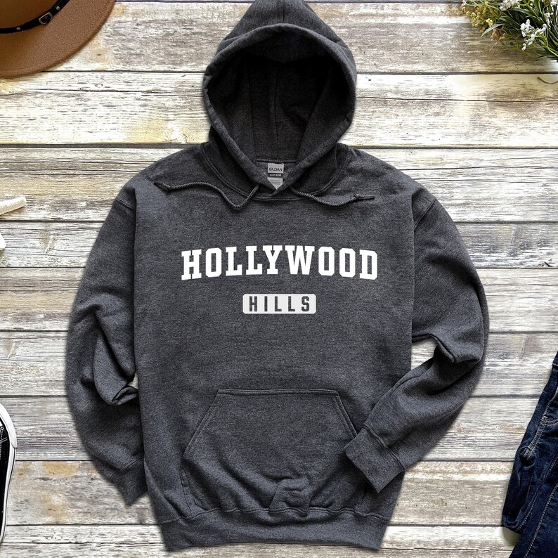 May include: A dark gray hooded sweatshirt with the text "HOLLYWOOD HILLS" in white lettering.