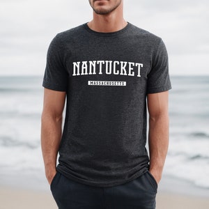 Könnte beinhalten: Ein dunkel-melierter grauer T-Shirt mit einem weißen Grafikdruck, auf dem "NANTUCKET MASSACHUSETTS" steht.