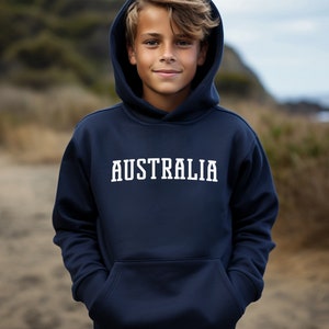 Puede incluir: Una sudadera con capucha azul marino con la palabra "AUSTRALIA" impresa en blanco en la parte delantera.